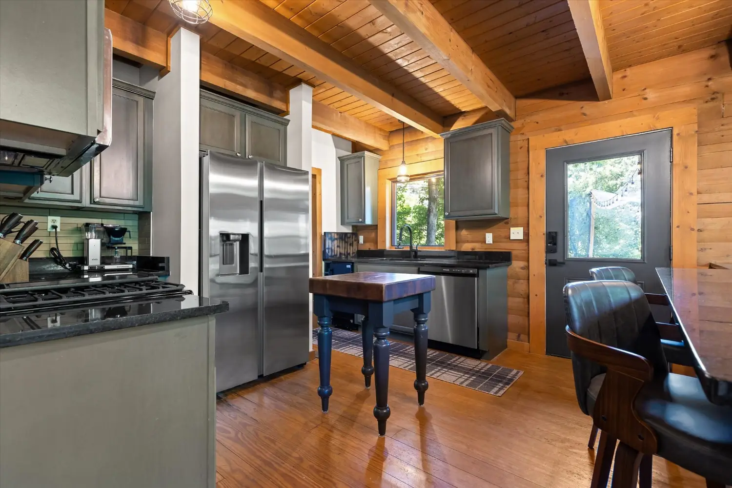 Kitchen with butcher-block island, stainless appliances and a long walnut dining table